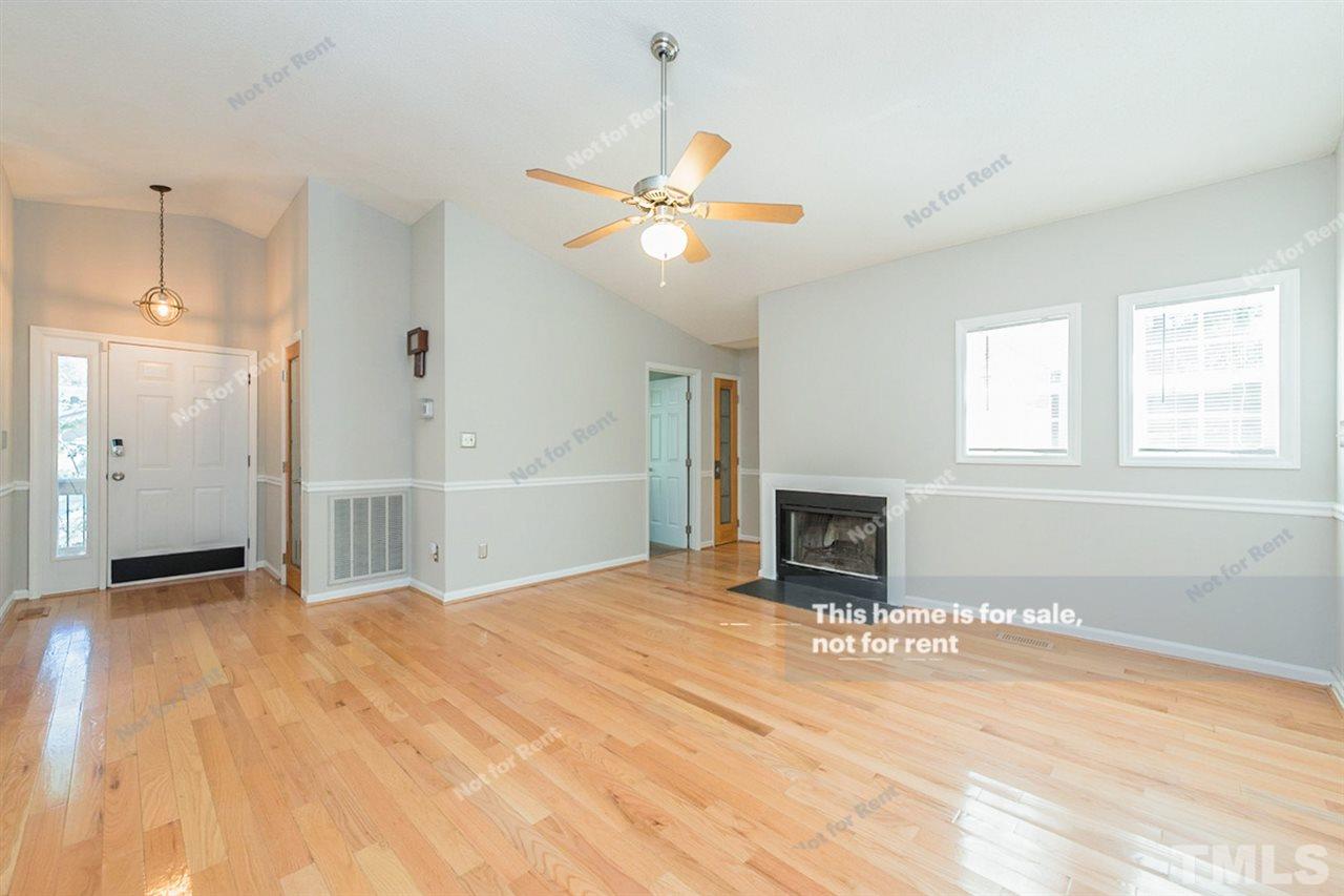 2412 Calvert Drive Raleigh, NC 27610 - Photo 3 of 19 a view of a livingroom with a fireplace a ceiling fan and windows