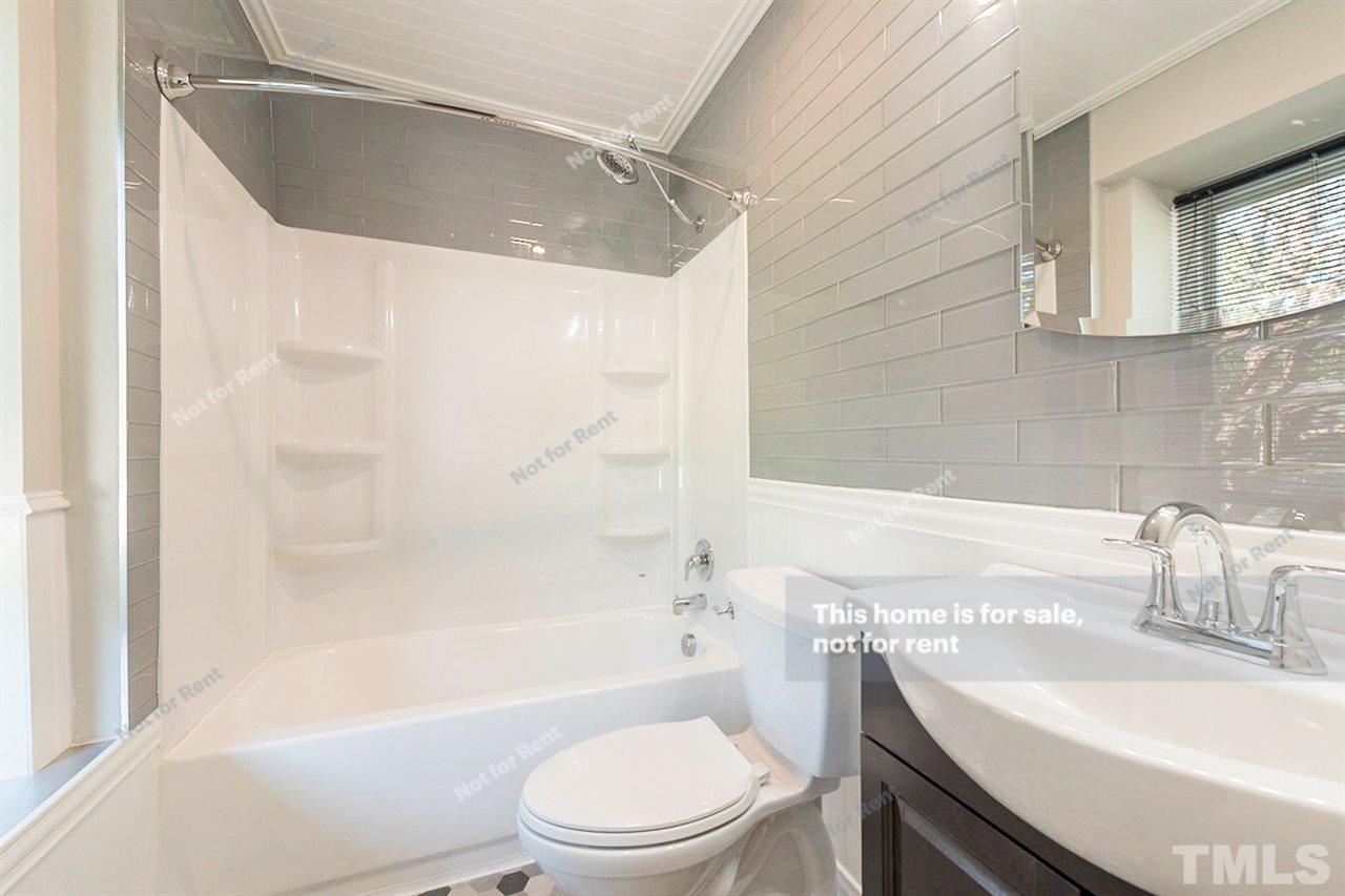 2412 Calvert Drive Raleigh, NC 27610 - Photo 4 of 19 a bathroom with a sink a toilet and a bathtub