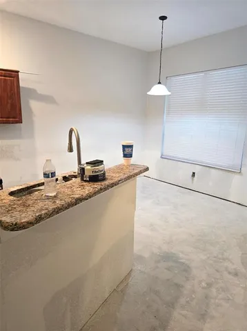 a kitchen with granite countertop a sink a stove and cabinets
