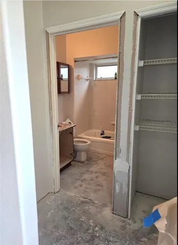 a white bath tub sitting next to a white sink and vanity