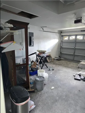 a backyard of a house with plants and large tree