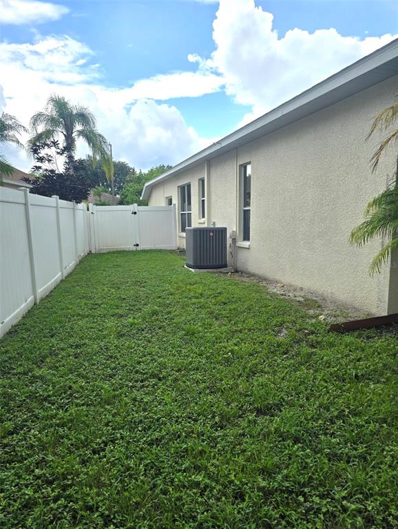 8640 Hawbuck Street Trinity, FL 34655 - Photo 30 of 33 a backyard of a house with plants and large tree