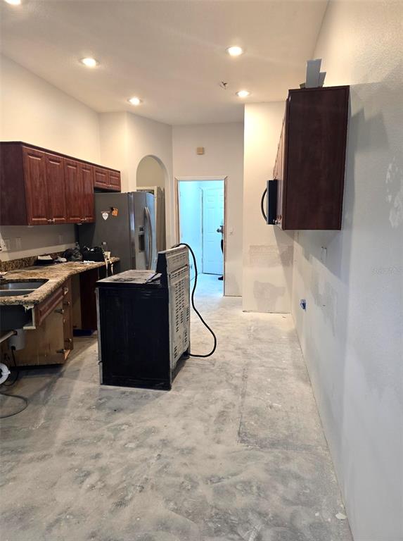 8640 Hawbuck Street Trinity, FL 34655 - Photo 8 of 33 a kitchen with stainless steel appliances a refrigerator and a wooden cabinets