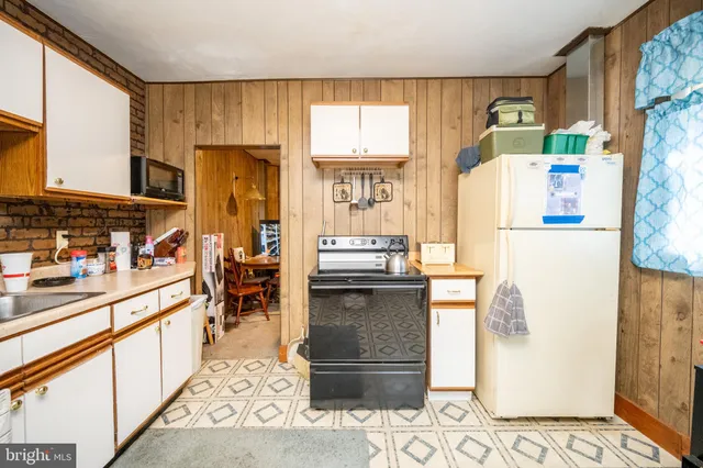 a kitchen with refrigerator and cabinets