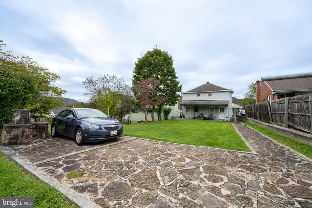 a car parked in front of a house and a yard