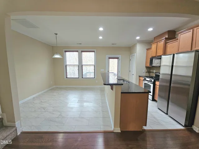 a view of a kitchen with refrigerator and windows