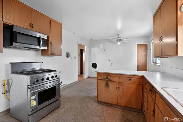 a kitchen with stainless steel appliances white cabinets and a stove top oven