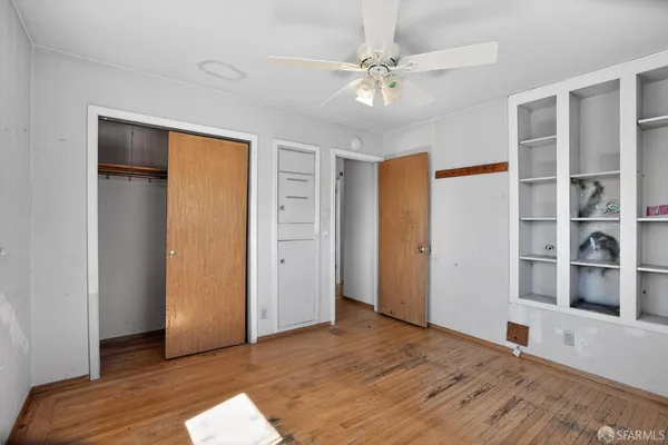 a view of an empty room with window and wooden floor