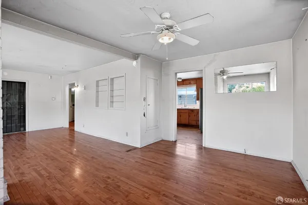 a view of an empty room with wooden floor