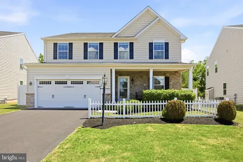 a front view of a house with a garden and plants