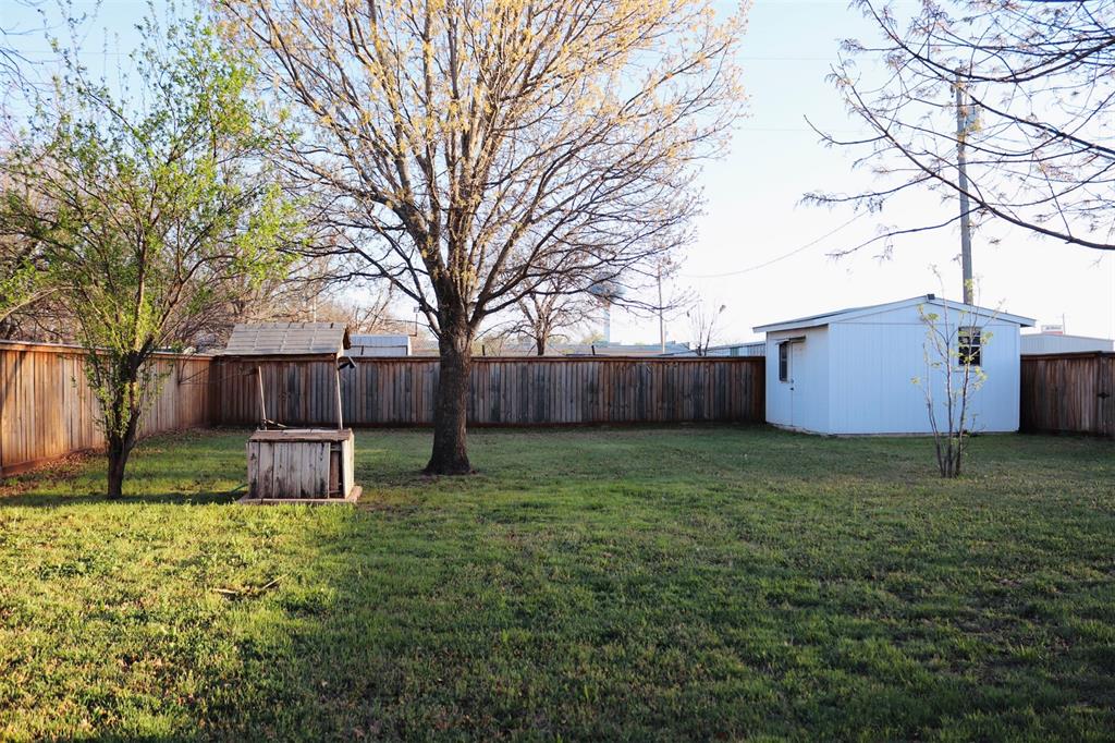109 Novice Road Winters, TX 79567 - Photo 15 of 32 a view of a backyard with large trees and a barn
