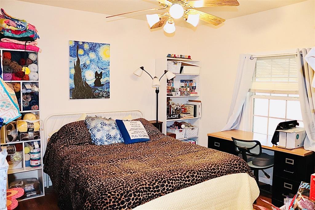 109 Novice Road Winters, TX 79567 - Photo 23 of 32 a bedroom with a bed and a chandelier