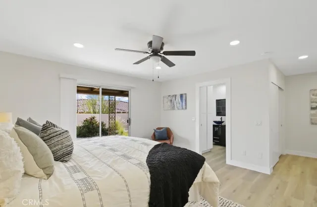 a bedroom with a bed ceiling fan and a couch