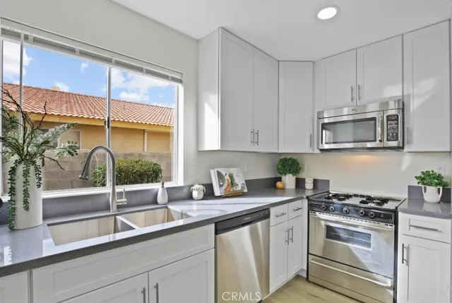a kitchen with stainless steel appliances white cabinets and a stove top oven
