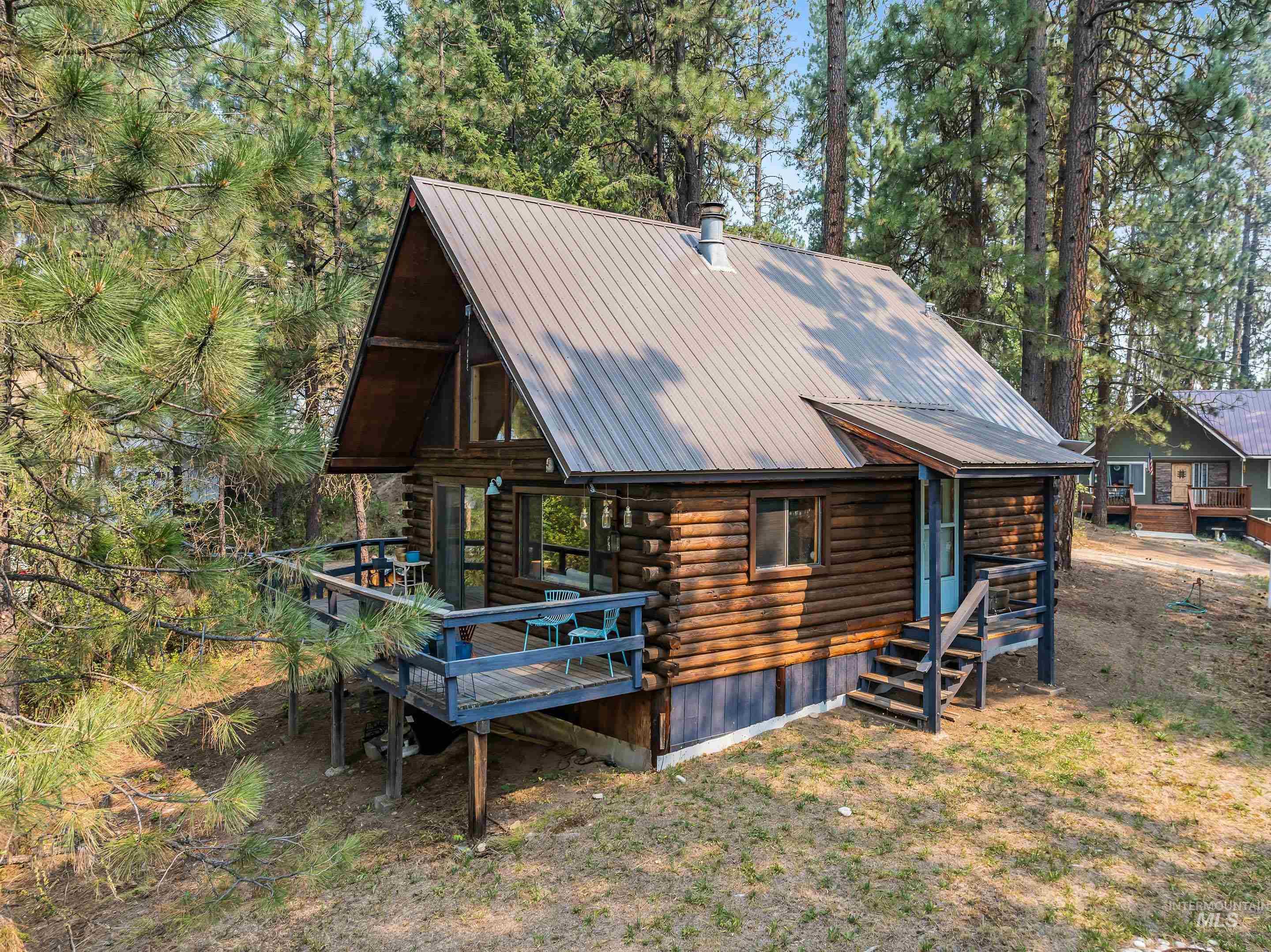 73 Rainbow Ridge Road Garden Valley, ID 83622 - Photo 2 of 49 Log cabin exterior with a metal A-frame roof and an elevated deck