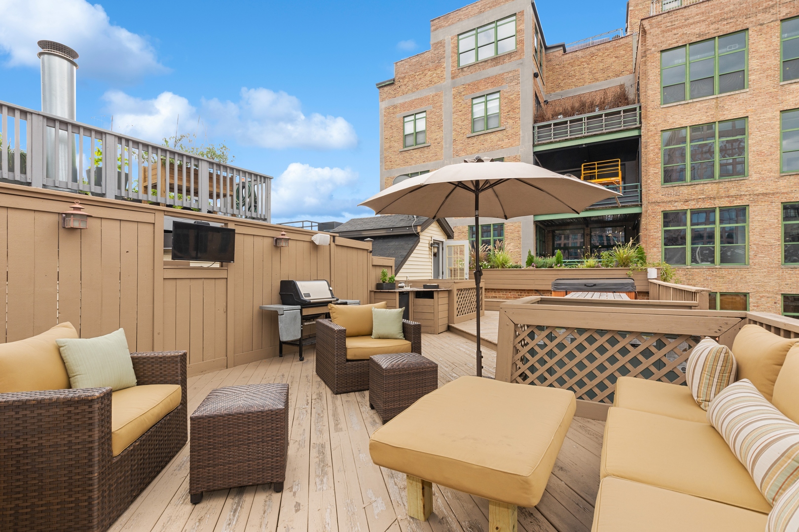 22 North Morgan Street, Unit 202 Chicago, IL 60607 - Photo 22 of 29 a view of a patio with couches table and chairs under an umbrella with a barbeque