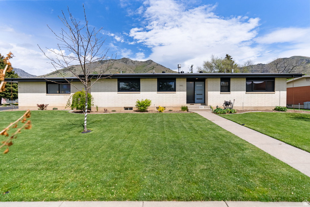 990 North 1500th Street East Logan, UT 84321 - Photo 1 of 1 Ranch-style residence featuring a light-colored brick exterior, a flat roofline, and contrasting dark window frames