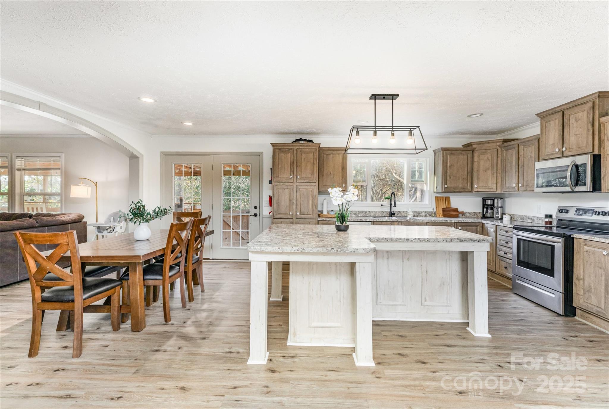 a kitchen with stainless steel appliances granite countertop a stove top oven a sink counter space and dining table
