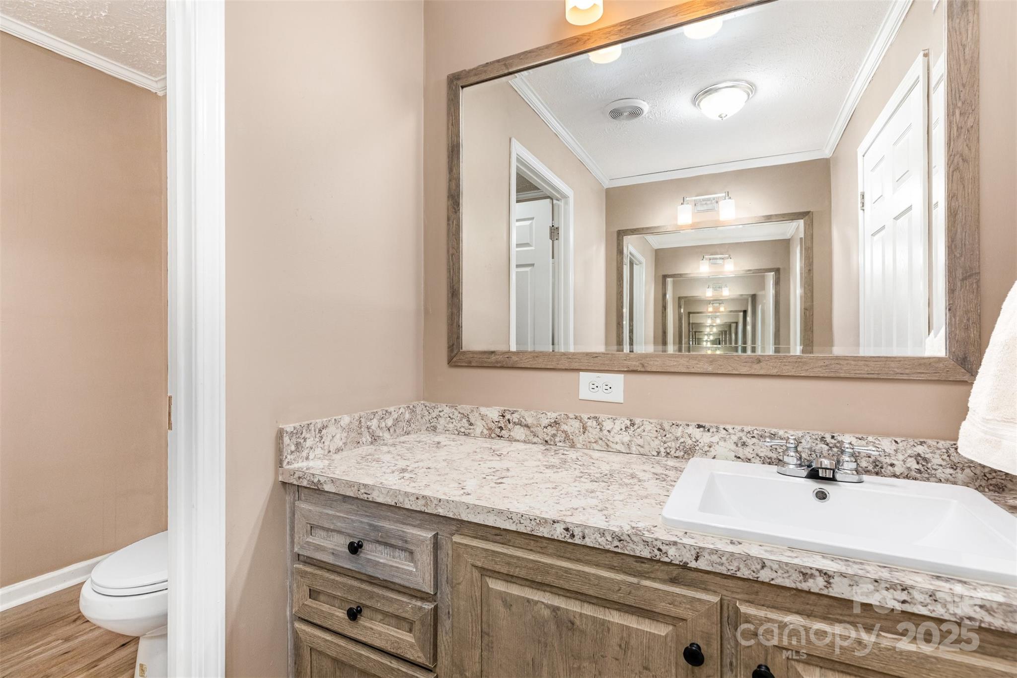 4110 Pebblebrook Circle Southwest Concord, NC 28027 - Photo 25 of 39 a bathroom with a granite countertop sink a toilet and a mirror