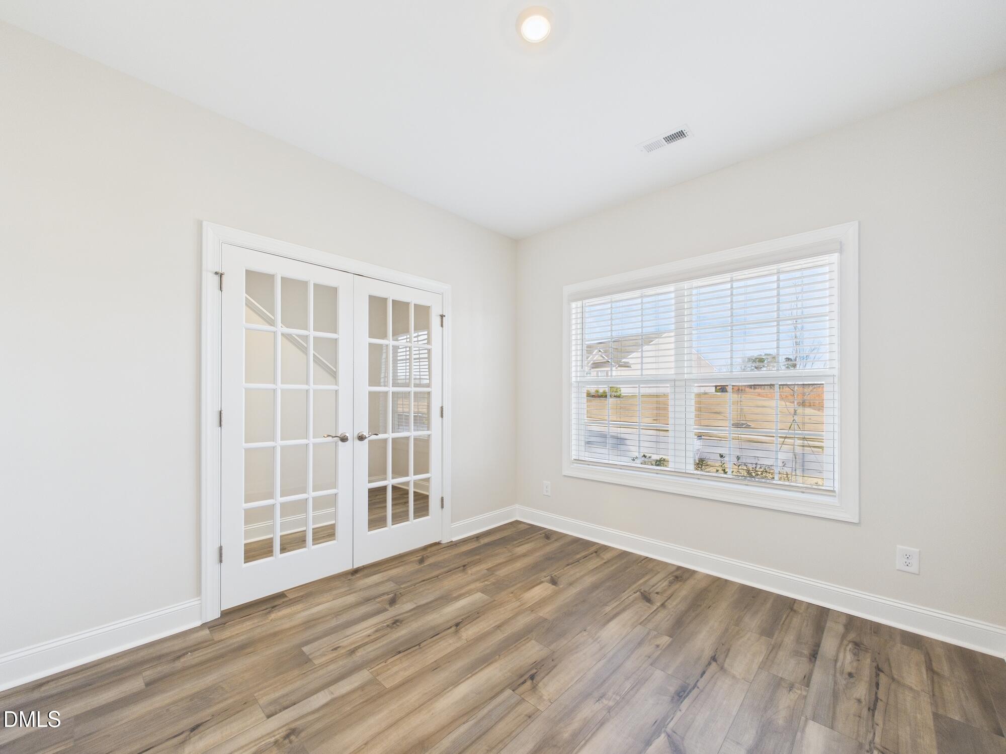110 Symmetry Loop Youngsville, NC 27596 - Photo 16 of 72 an empty room with wooden floor and windows