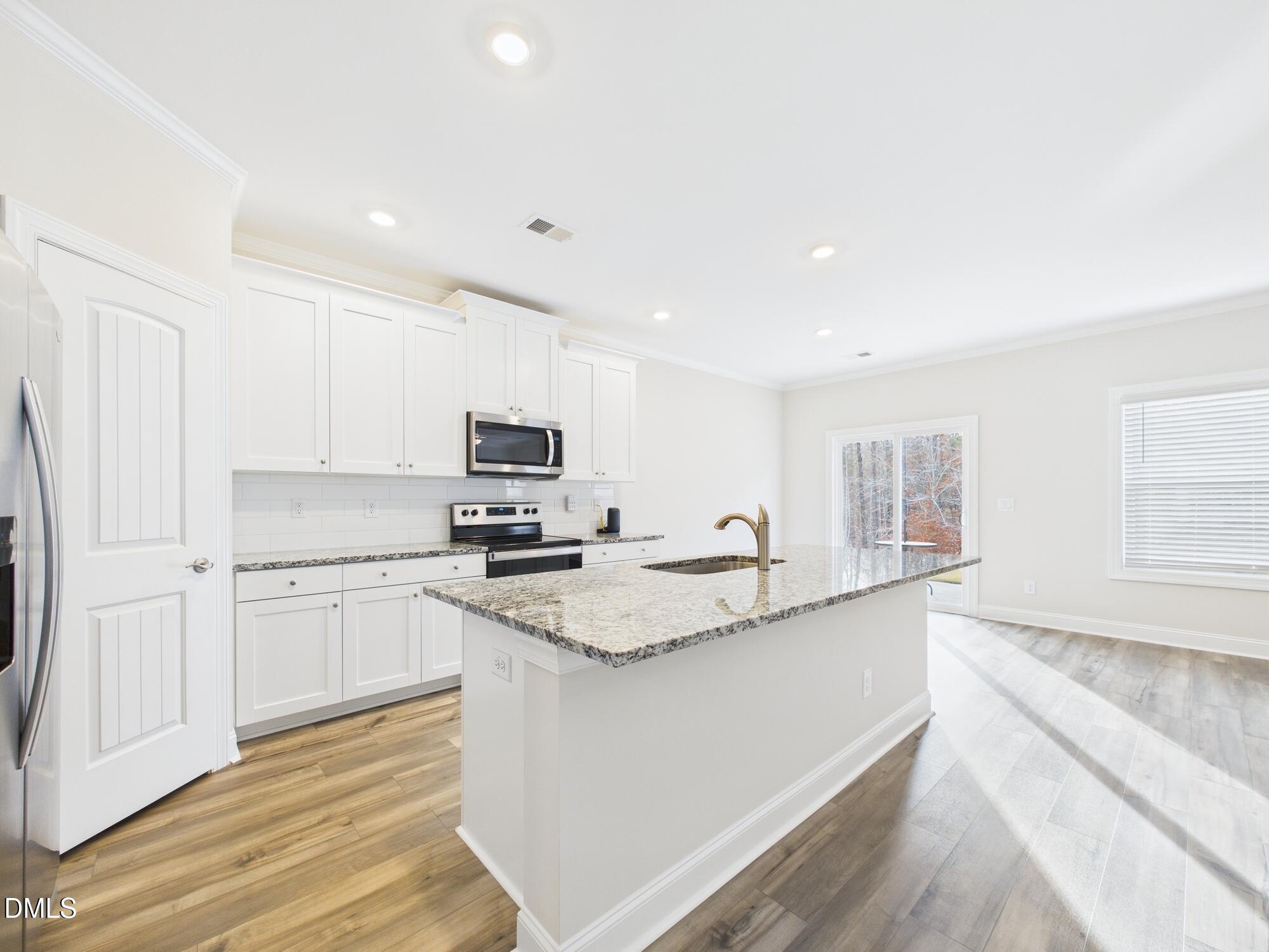 110 Symmetry Loop Youngsville, NC 27596 - Photo 18 of 72 a kitchen with stainless steel appliances granite countertop a sink a stove and a refrigerator