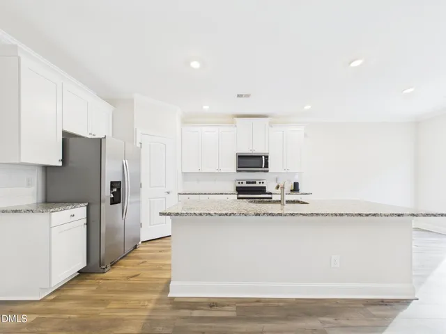 a view of a kitchen with wooden floor and a ceiling fan