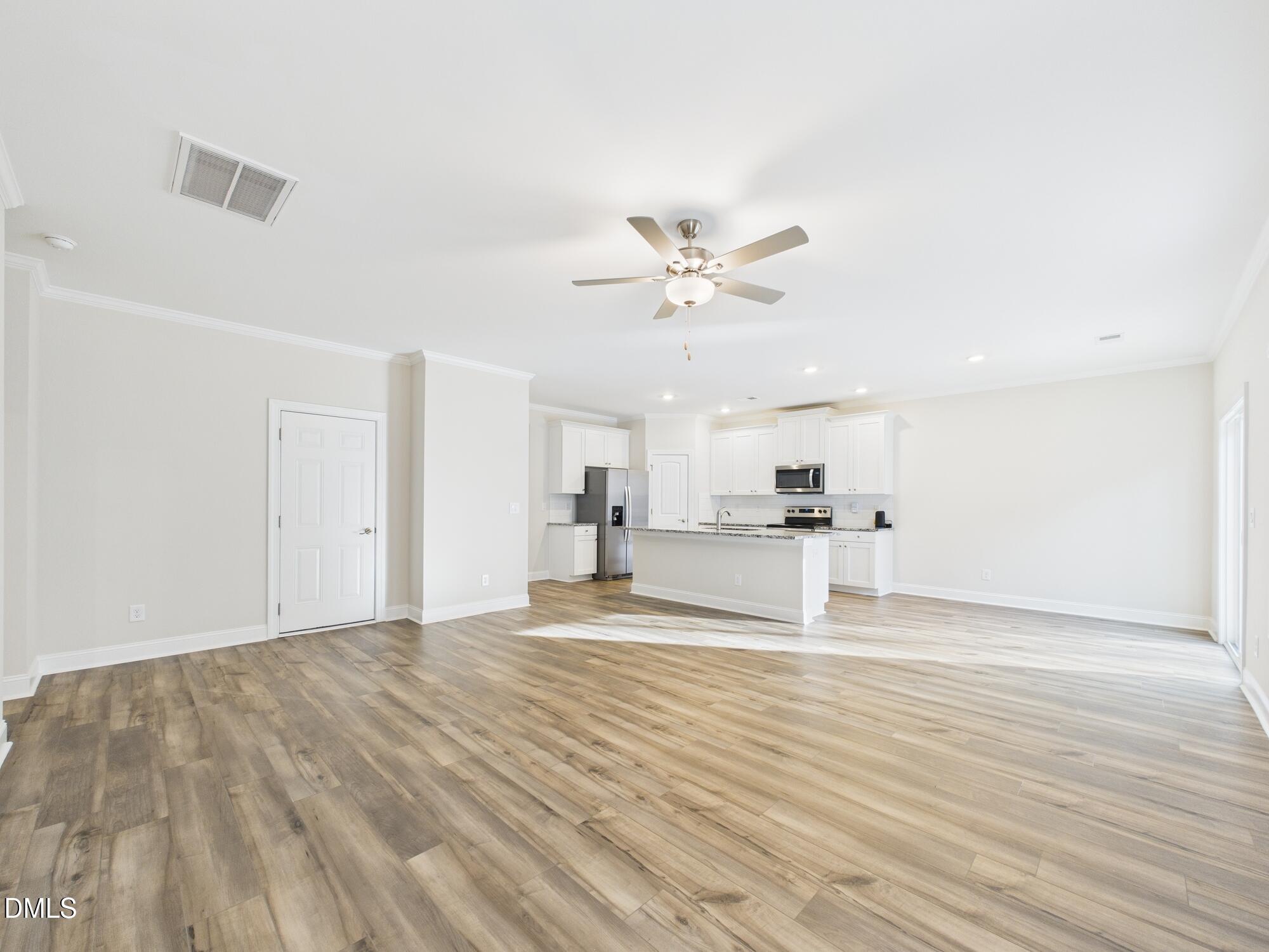 110 Symmetry Loop Youngsville, NC 27596 - Photo 30 of 72 a view of a kitchen with wooden floor and a ceiling fan