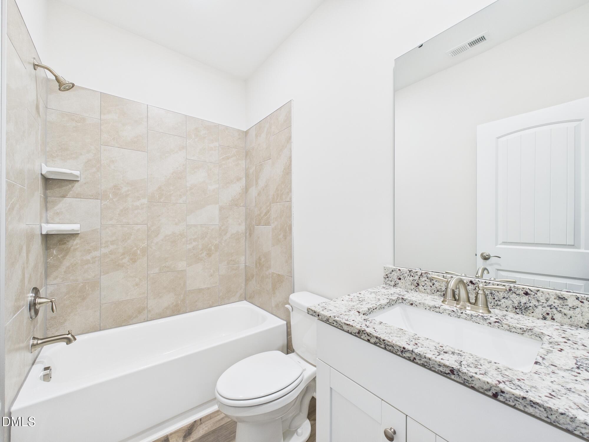 110 Symmetry Loop Youngsville, NC 27596 - Photo 31 of 72 a bathroom with a granite countertop sink toilet mirror and bathtub