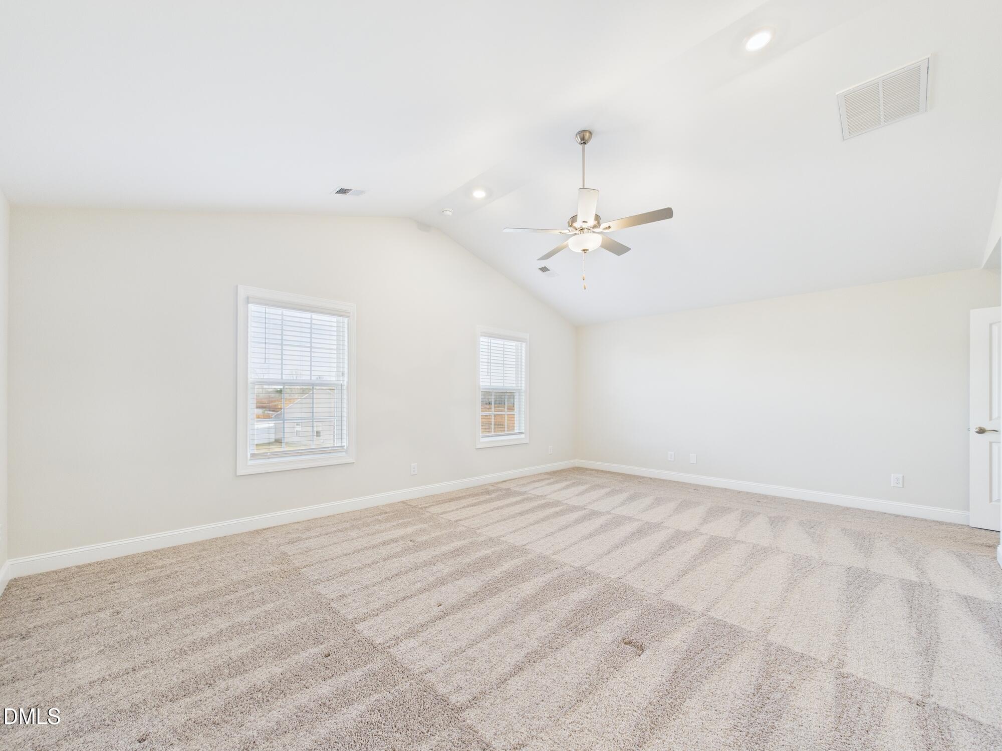 110 Symmetry Loop Youngsville, NC 27596 - Photo 39 of 72 an empty room with a chandelier fan and windows