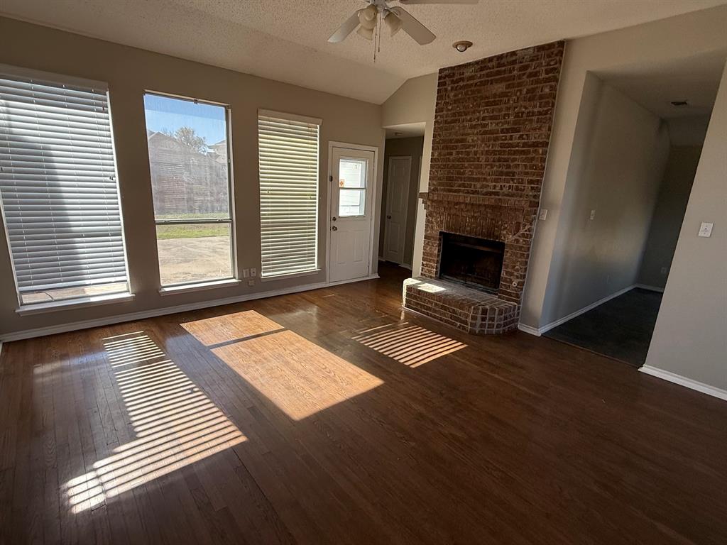 10931 Castle Drive Frisco, TX 75035 - Photo 4 of 14 a view of an empty room with wooden floor fireplace and a window
