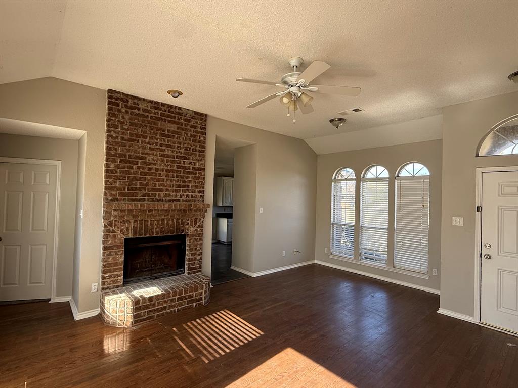 10931 Castle Drive Frisco, TX 75035 - Photo 5 of 14 a view of an empty room with wooden floor fireplace and a window