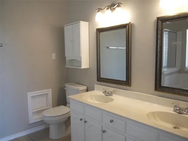 a bathroom with a toilet sink and mirror