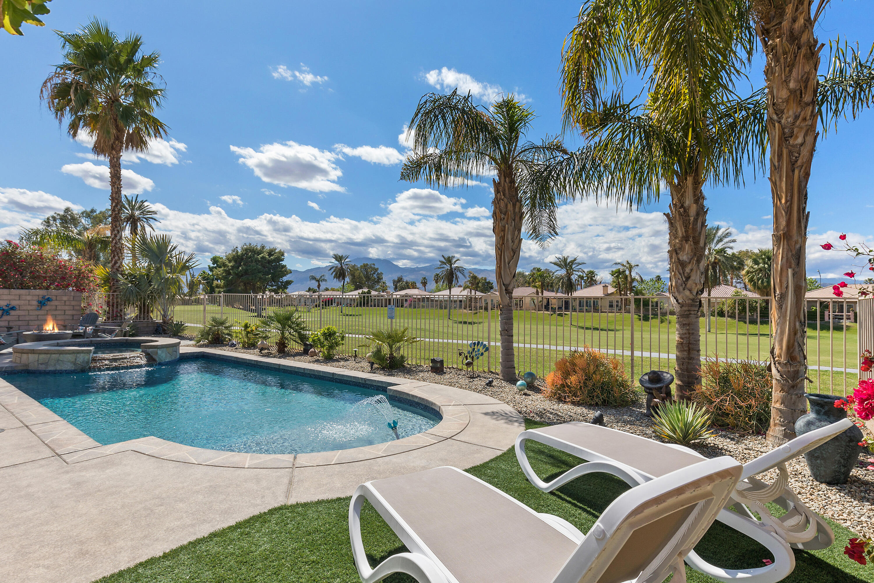 a view of a swimming pool and lounge chairs