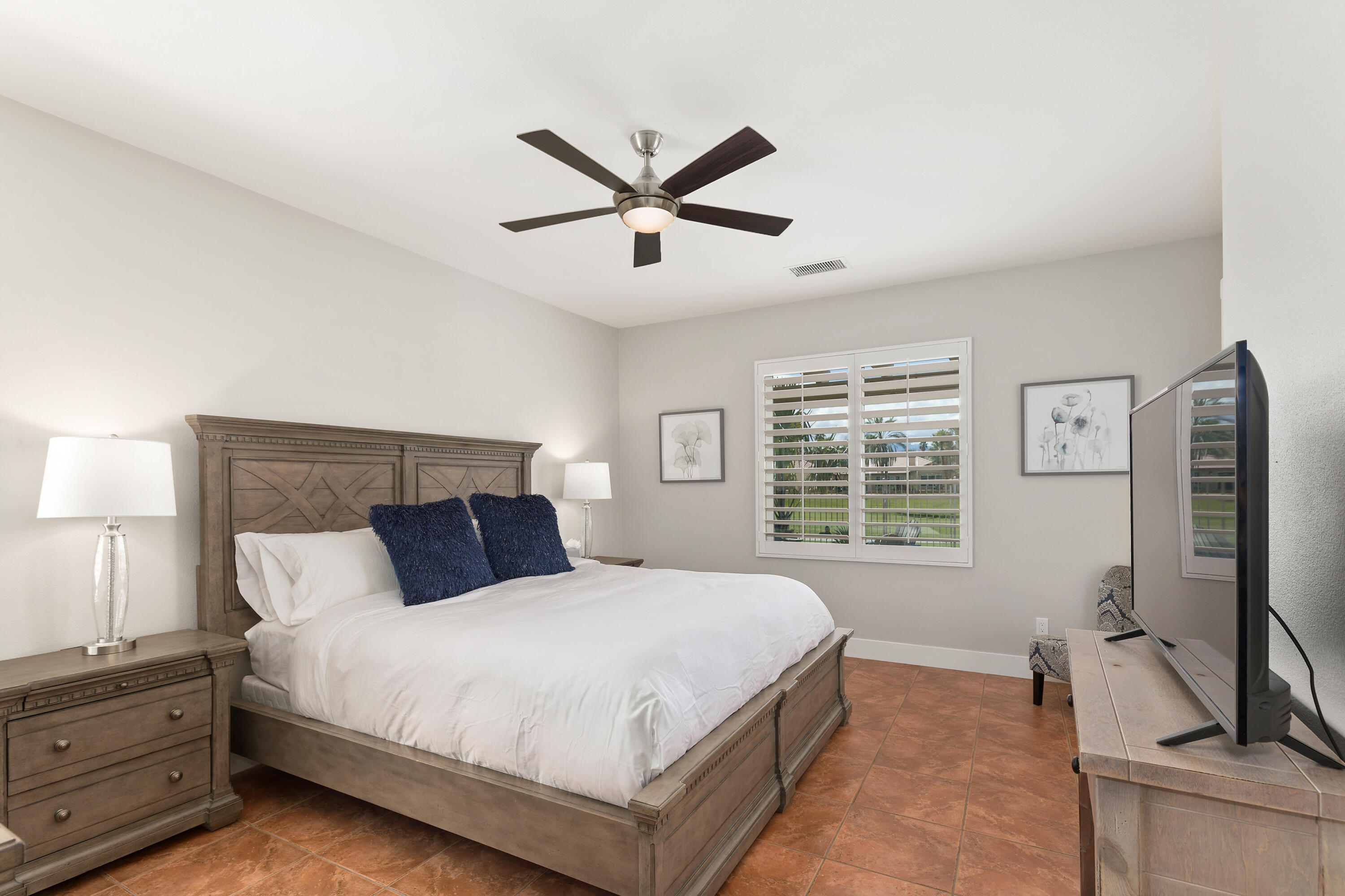 49377 Biery Street Indio, CA 92201 - Photo 12 of 32 a bedroom with a large bed and a flat tv screen on dresser
