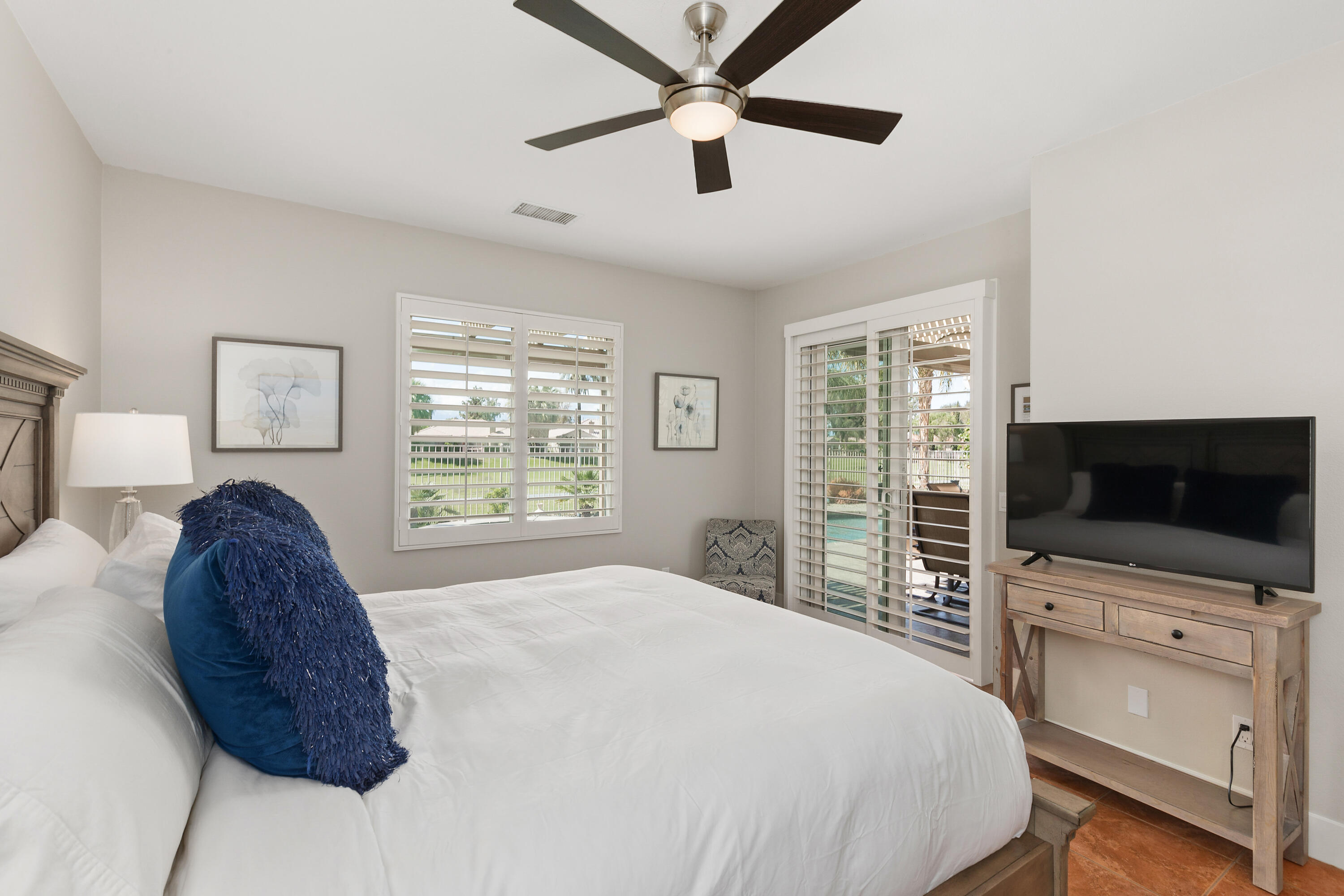 49377 Biery Street Indio, CA 92201 - Photo 13 of 32 a spacious bedroom with a bed and a flat screen tv