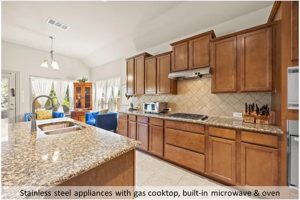a kitchen with kitchen island granite countertop wooden cabinets a sink and dishwasher