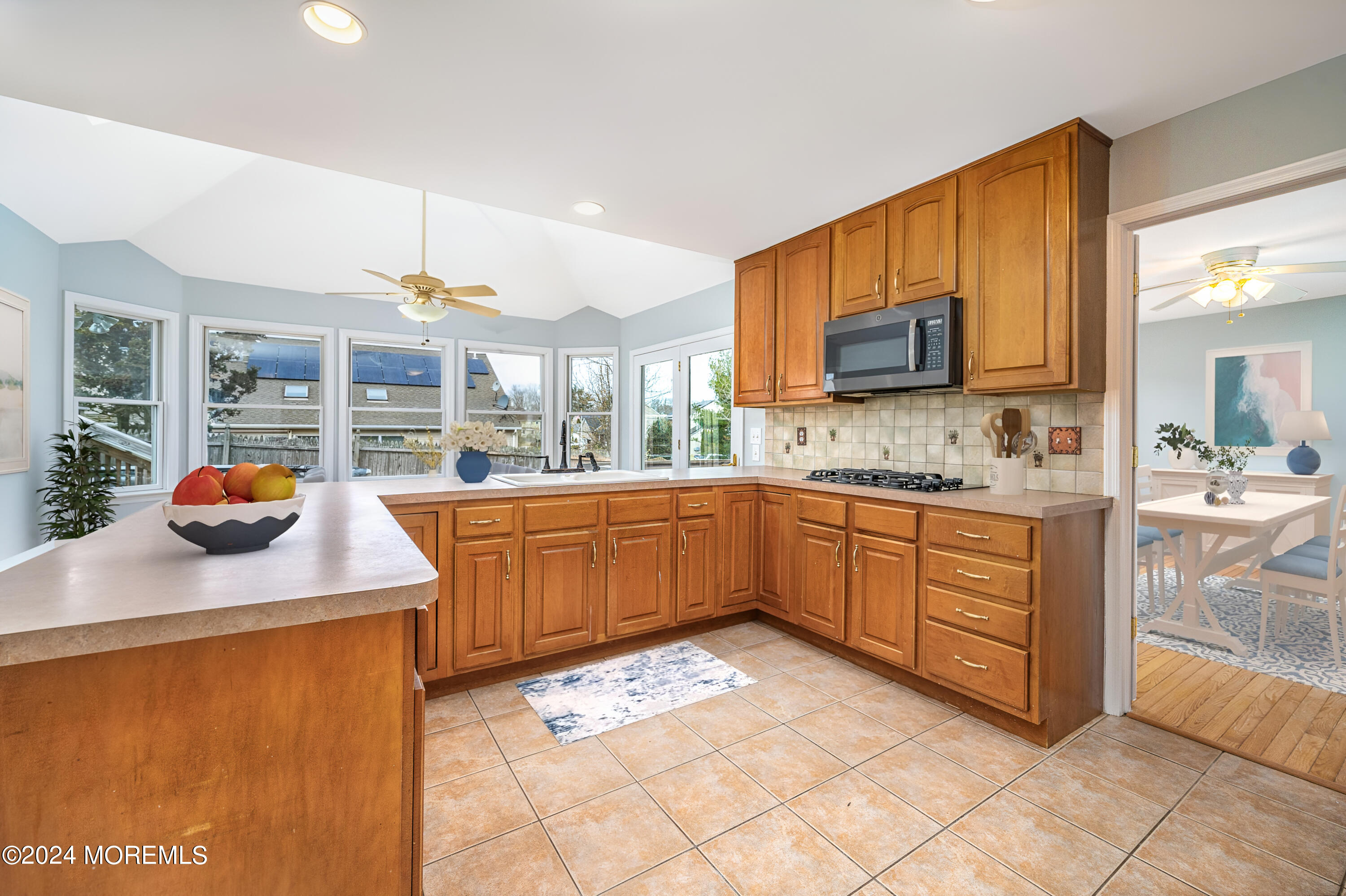 120 Leeward Road Manahawkin, NJ 08050 - Photo 9 of 23 a kitchen with stainless steel appliances kitchen island granite countertop a sink and a wooden cabinets