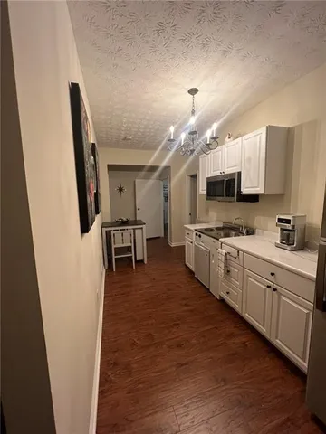 a kitchen with stainless steel appliances a stove top oven a sink a dining table and chairs