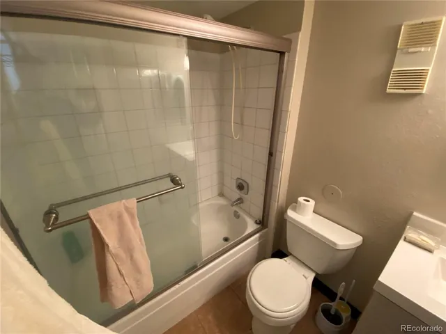 a white toilet sitting next to a bath tub