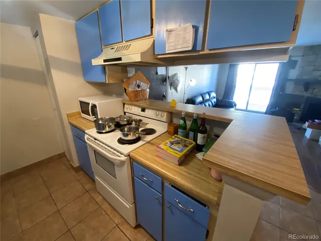 a kitchen with a stove and a wooden floor