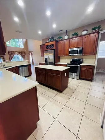 a kitchen with stainless steel appliances a stove a sink a microwave and a refrigerator