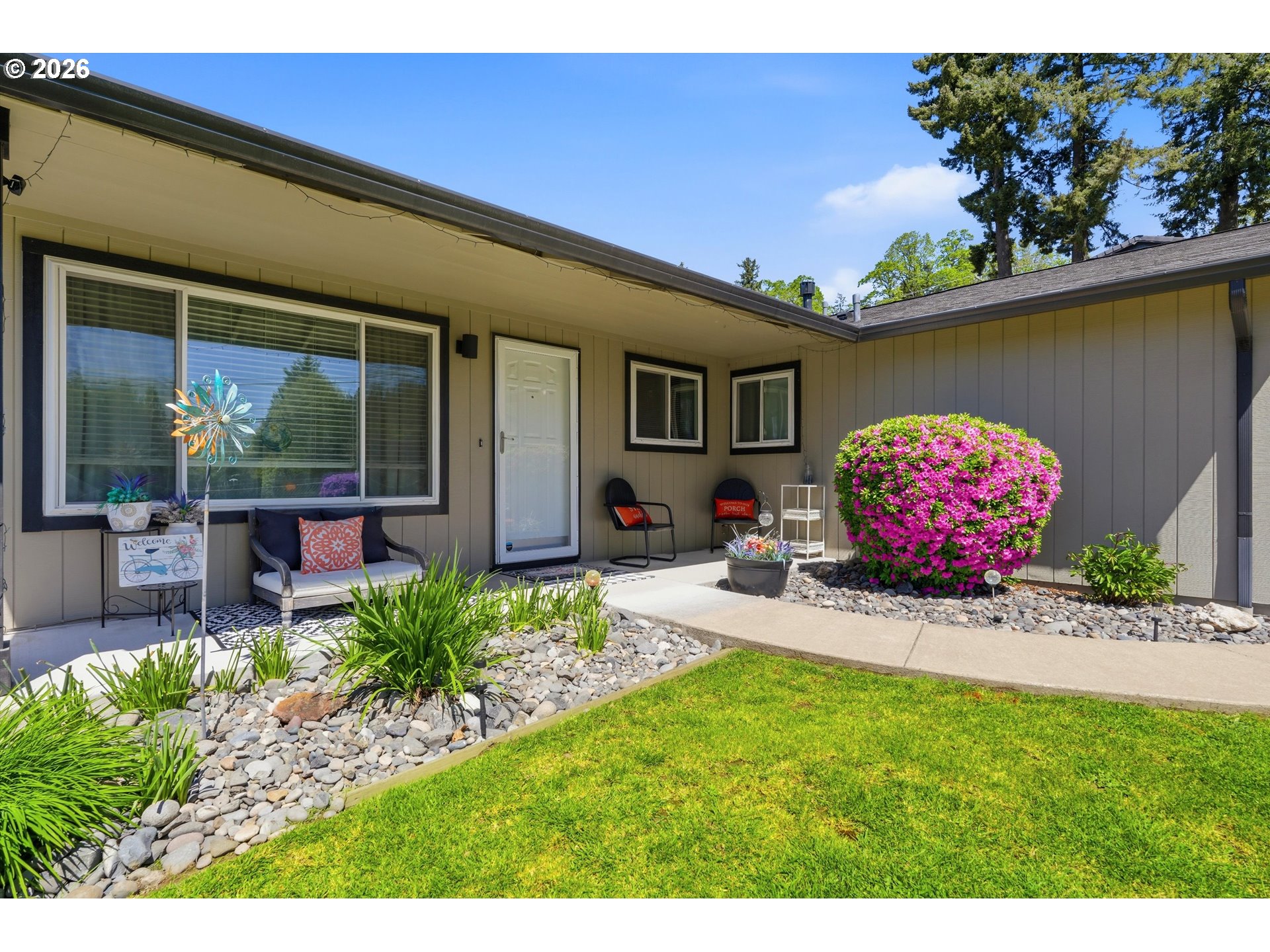 5095 Southeast Roethe Road Milwaukie, OR 97267 - Photo 3 of 28 a front view of a house with a garden and patio