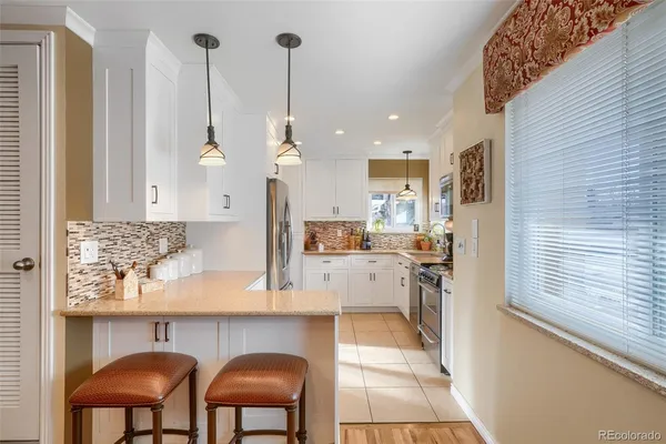 a kitchen with cabinets and chairs