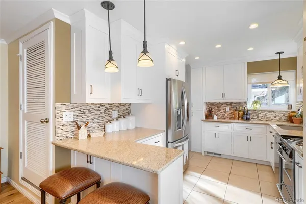 a kitchen with stainless steel appliances granite countertop a sink a stove and a refrigerator