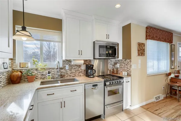 a kitchen with stainless steel appliances granite countertop a sink stove and cabinets