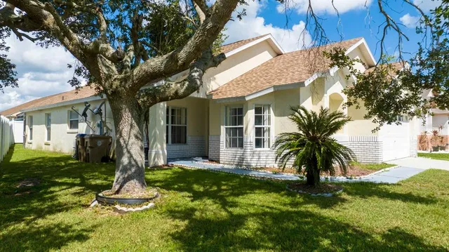 a front view of a house with a yard and palm tree