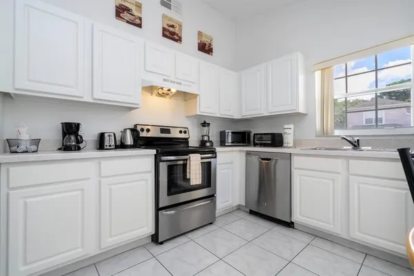 a kitchen with white cabinets and white appliances