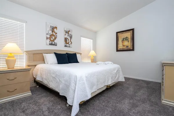 a bedroom with a bed and painting on the wall