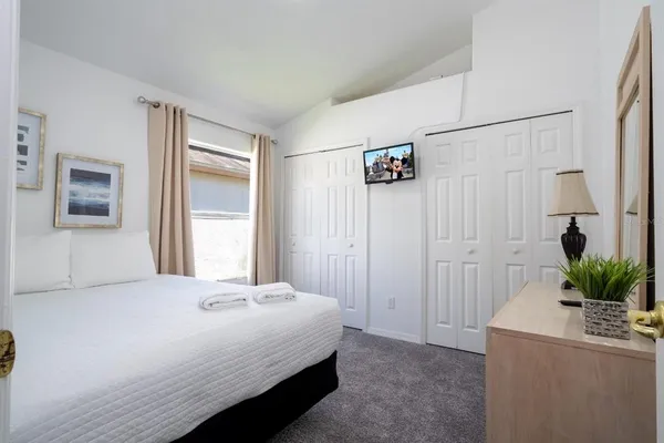 a bedroom with a bed potted plant with the wooden floor