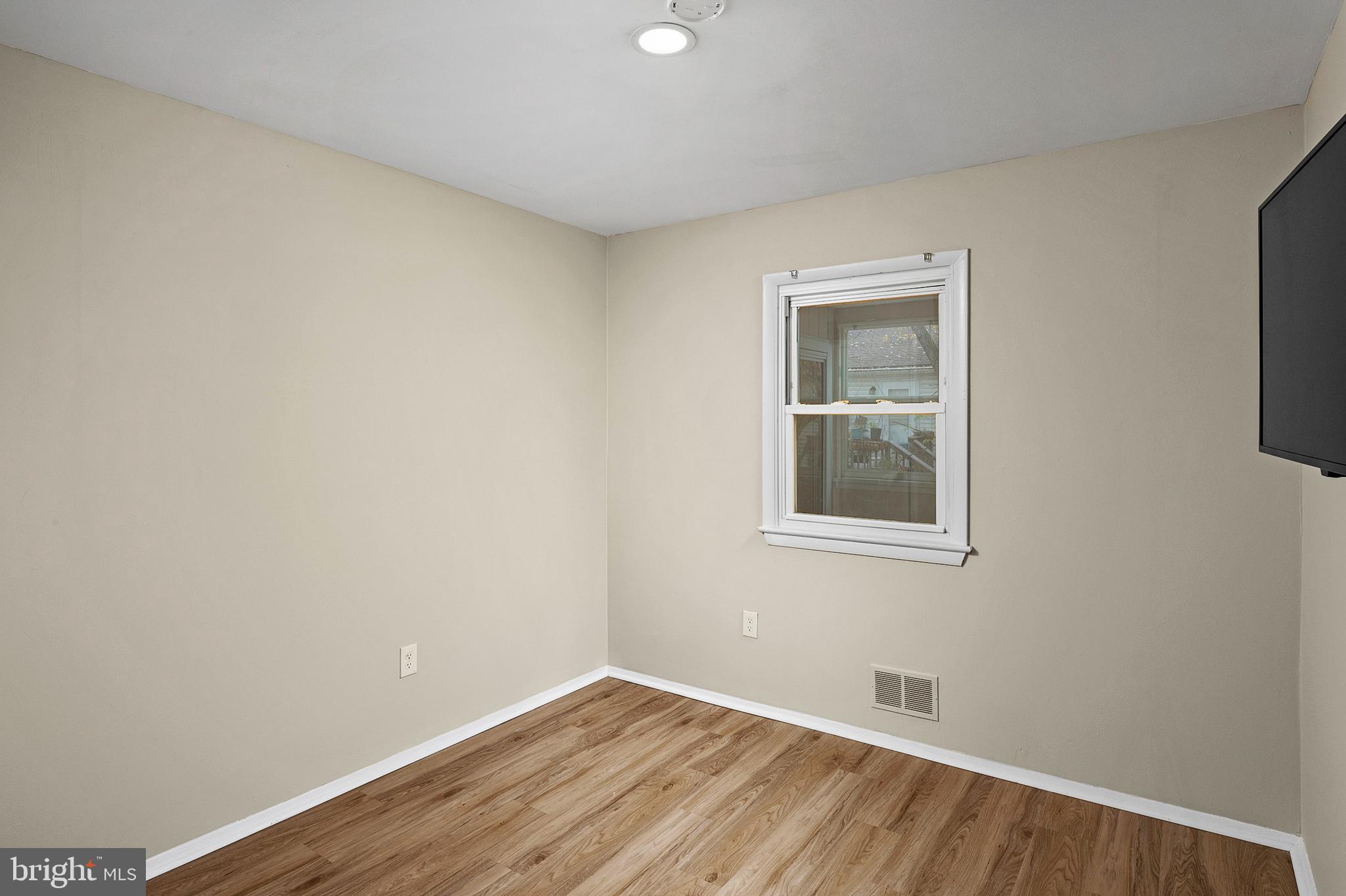8084 Clark Station Road Severn, MD 21144 - Photo 15 of 36 a view of an empty room with wooden floor and a window